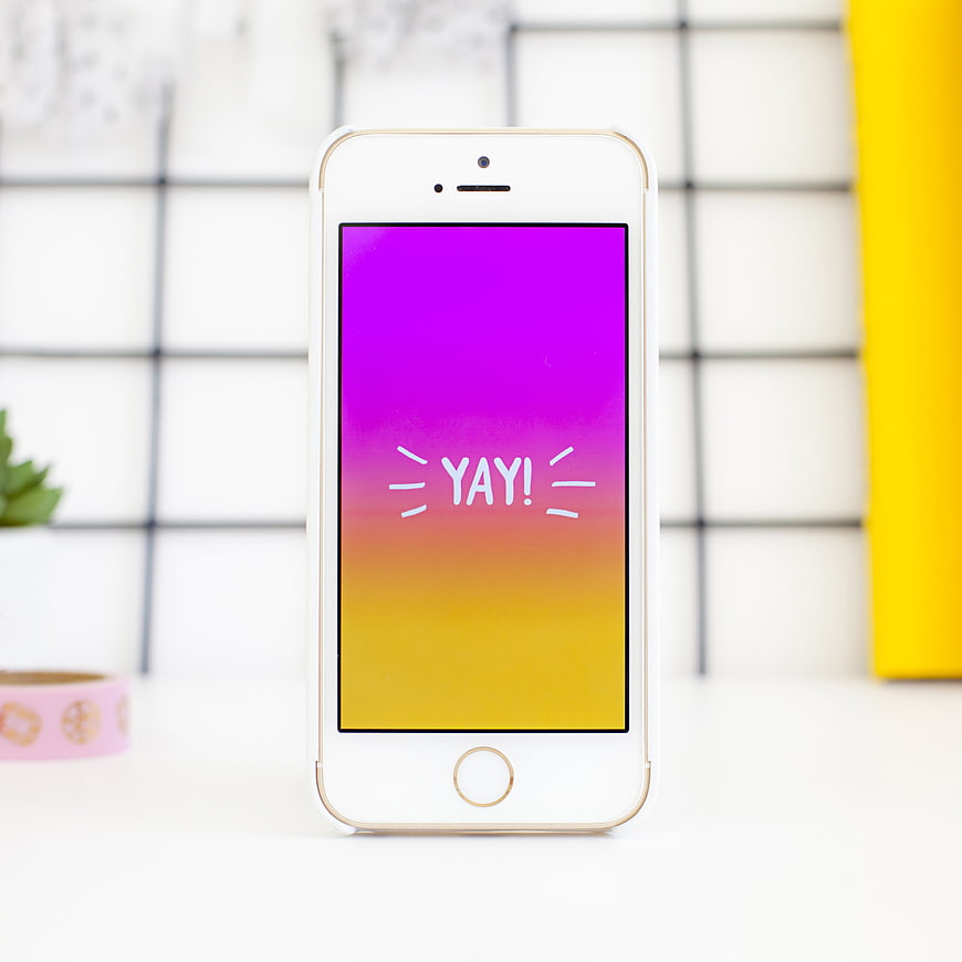 White Smartphone with Colorful Yay Screen on Desk