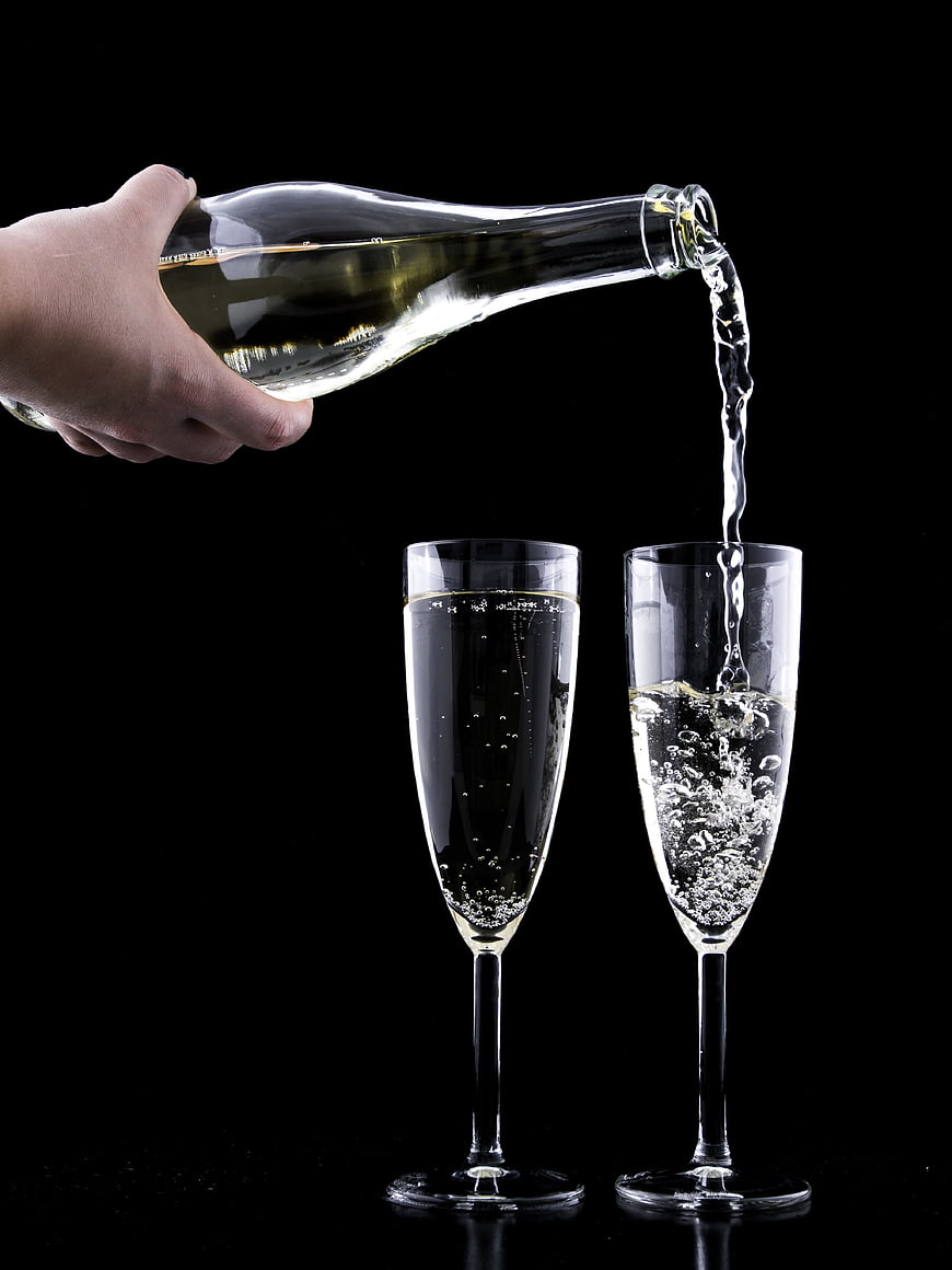 Pouring Champagne into Glasses on Black Background