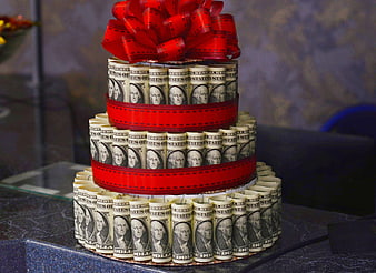 Three-tiered money cake made of rolled hundred dollar bills