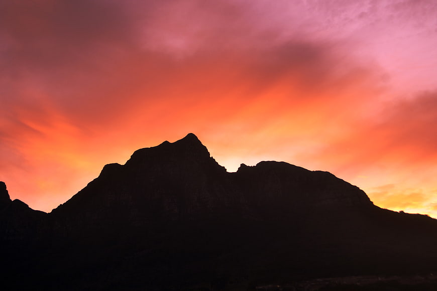 Dramatic Mountain Silhouette Against Fiery Sunset Sky