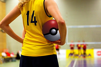 Volleyball player holding a red and white Poké Ball in an indoor gym