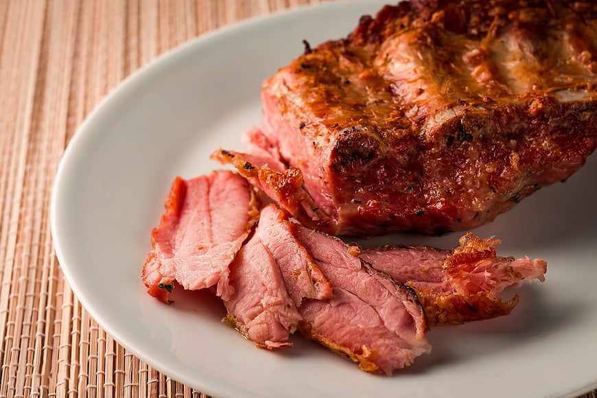 Close-up of sliced roasted pork ribs on a white plate