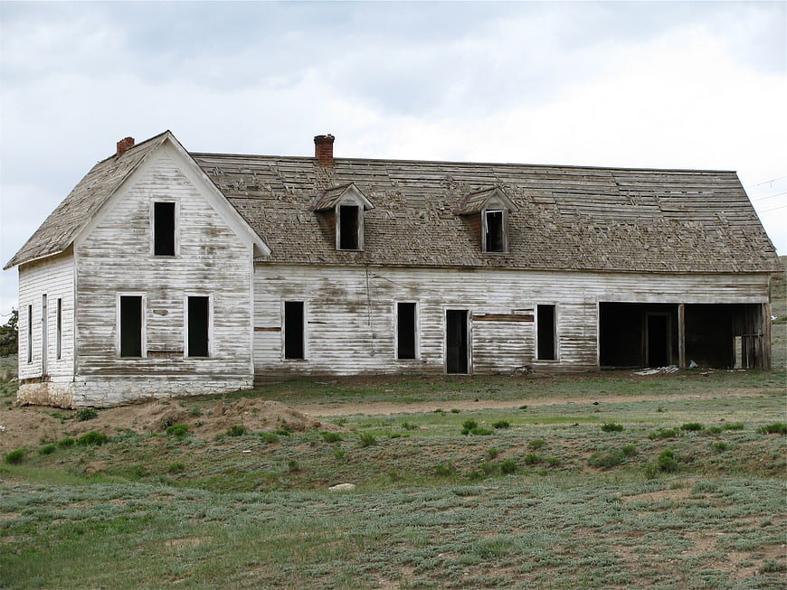 Abandoned Weathered White Farmhouse in Rural Landscape
