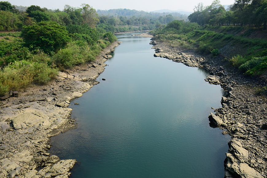 Calm River Flowing Through Rocky Landscape With Green Vegetation