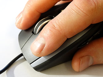 Close-up of hand using computer mouse scroll wheel