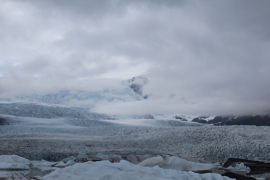 Misty Glacier Landscape with Floating Icebergs and Cloudy Sky