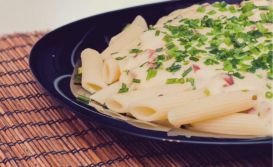 Creamy Penne Pasta with Chives on Black Plate