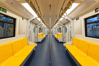 Empty subway train interior with yellow seats and blue floor