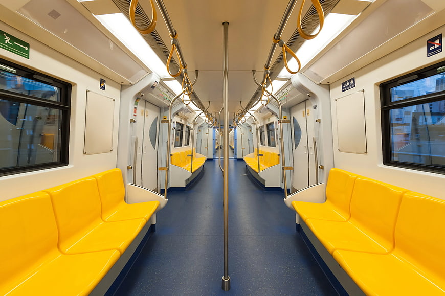 Empty subway train interior with yellow seats and blue floor
