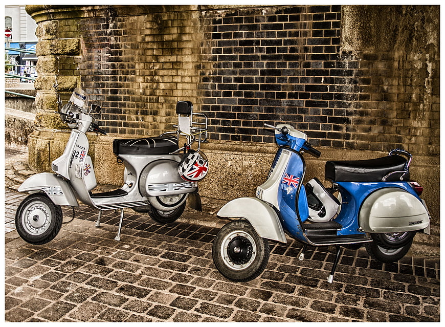 Vintage scooters parked on cobblestone street