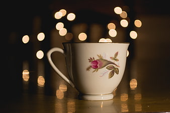 Vintage Floral Teacup with Warm Bokeh Lights Background