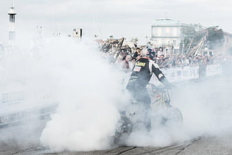 Motorcyclist performing burnout stunt with smoke