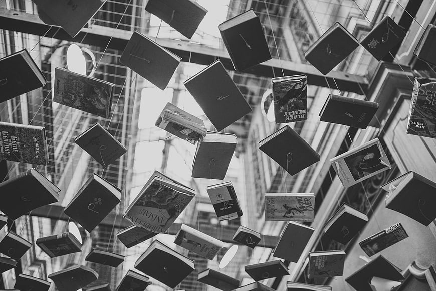 Black and white photo of hanging books in a bookstore