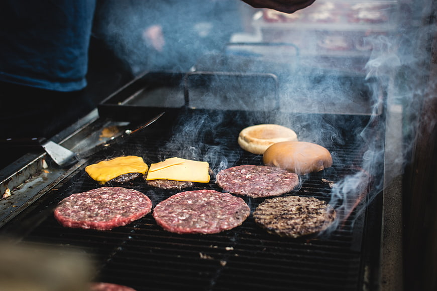 Grilling Beef Burgers and Cheese on Outdoor BBQ Grill