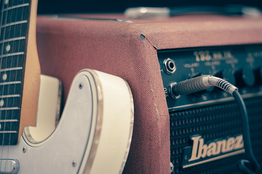 Close-up of electric guitar and Ibanez amplifier with cable