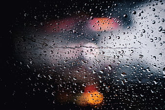 Raindrops on Window Glass with Blurred City Lights