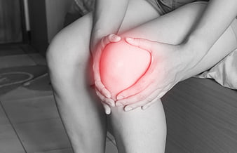 Woman holding knee in pain with red glow effect