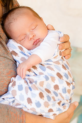 Sleeping Newborn Baby Wrapped in Patterned Blanket