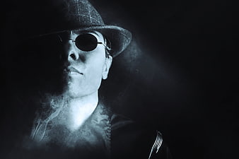 Mysterious man in fedora and sunglasses with smoke