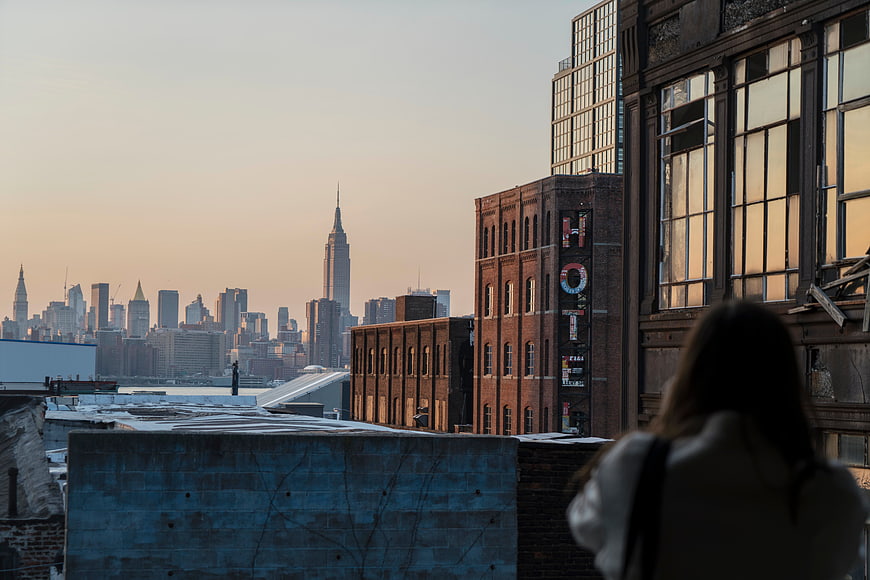 Woman on Rooftop Viewing New York City Skyline at Sunset
