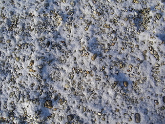 Close-up of pebbles and stones covered in fresh snow