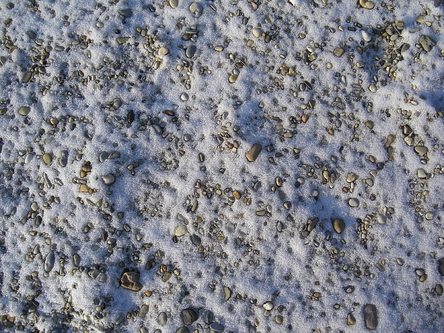 Close-up of pebbles and stones covered in fresh snow
