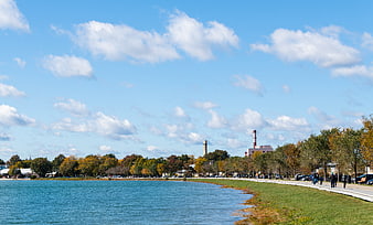 Scenic waterfront park with autumn trees and blue sky