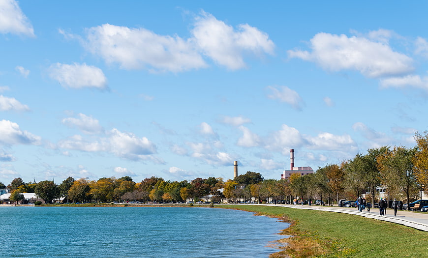 Scenic waterfront park with autumn trees and blue sky