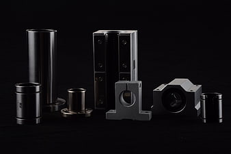Assortment of precision metal mechanical components on black background