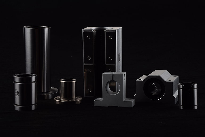 Assortment of precision metal mechanical components on black background