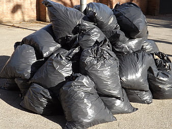Pile of black plastic garbage bags on a city street