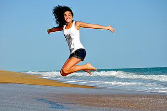 Happy Woman Jumping on Sandy Beach