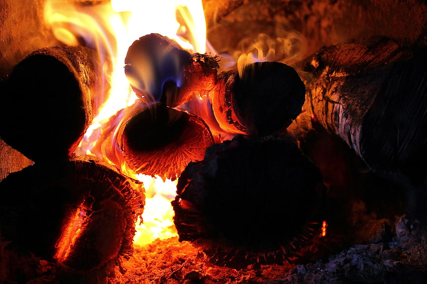 Close-up of burning logs in a fireplace with bright flames