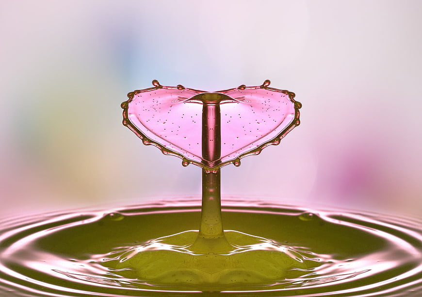 Pink liquid splash forming a heart shape in macro photography