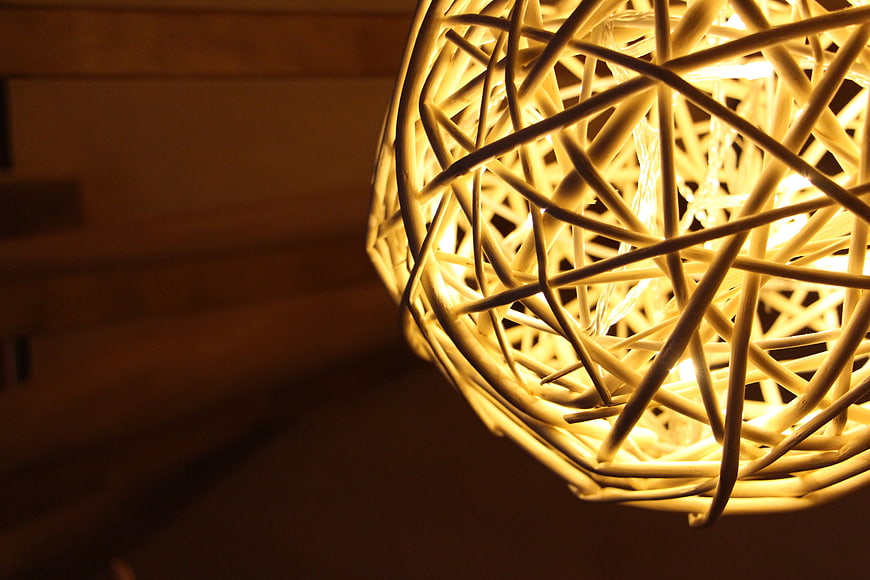 Close-up of glowing woven rattan pendant lamp