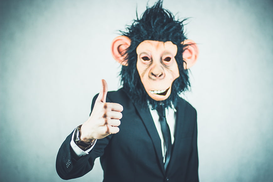 Man in Monkey Mask Giving Thumbs Up in Business Suit