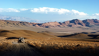 4x4 SUV driving on dirt road in Atacama Desert landscape