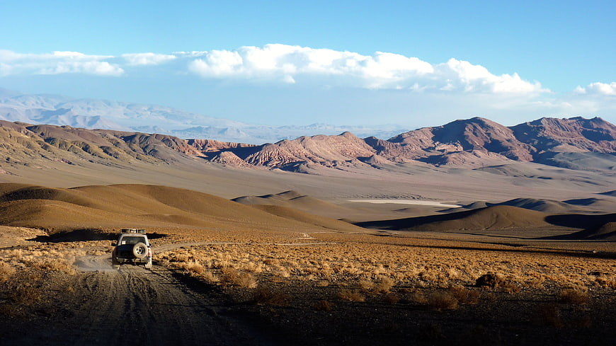 4x4 SUV driving on dirt road in Atacama Desert landscape