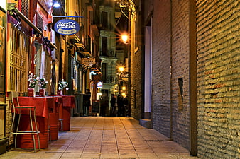 Narrow European Street at Night with Outdoor Dining