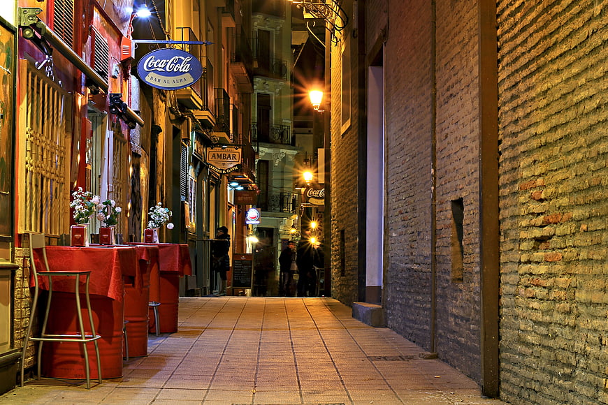 Narrow European Street at Night with Outdoor Dining