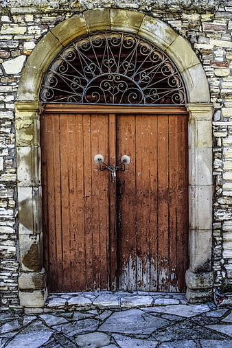 Old Wooden Door with Stone Archway and Iron Grille