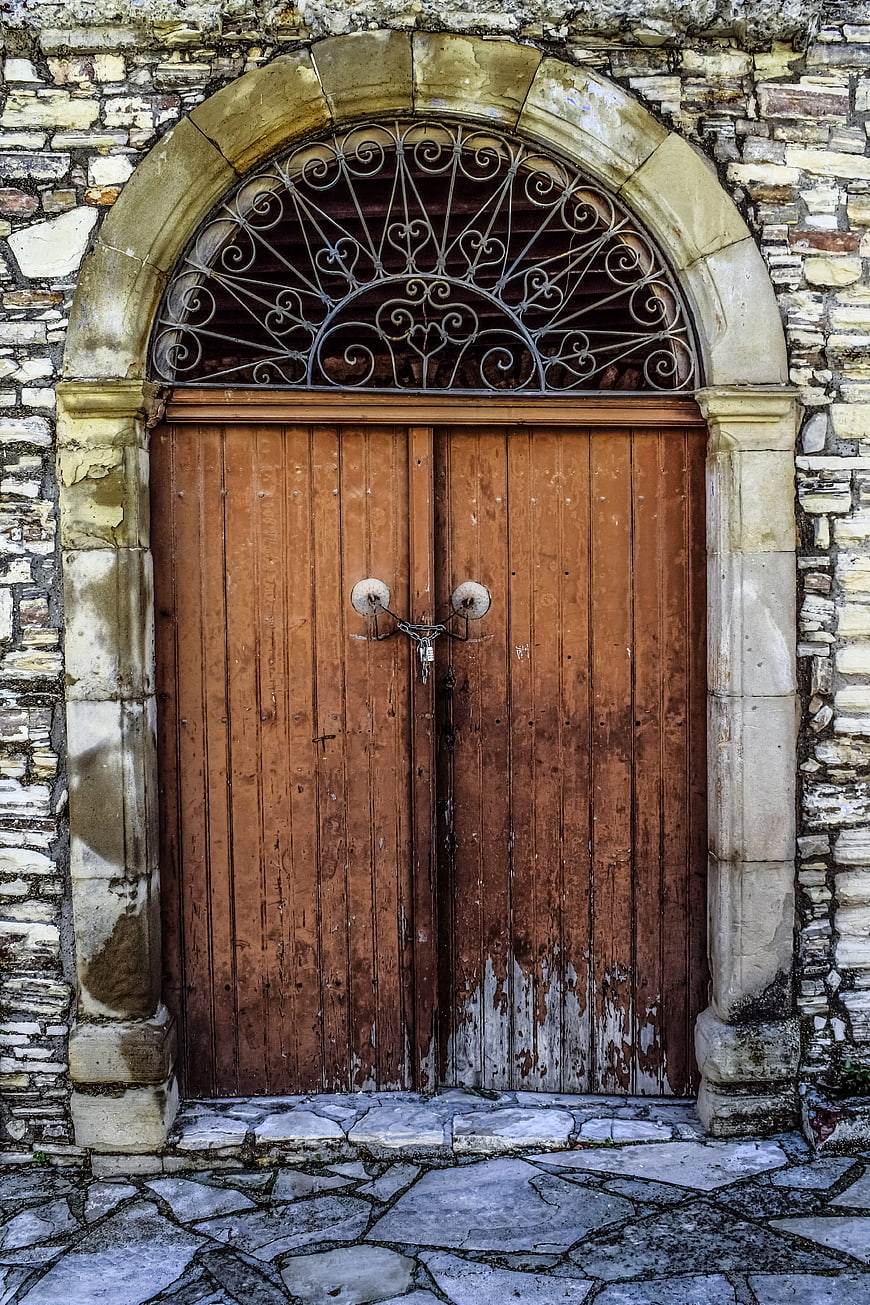 Old Wooden Door with Stone Archway and Iron Grille