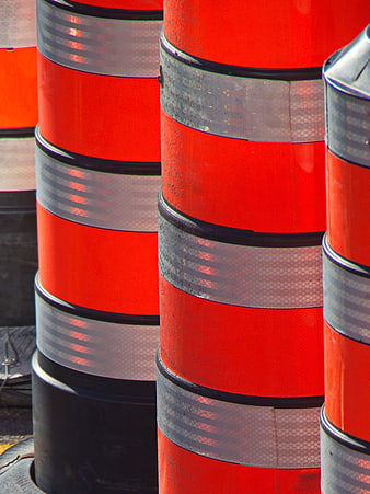 Close-up of stacked orange traffic cones with reflective stripes