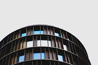 Modern curved building facade with blue windows and copyspace