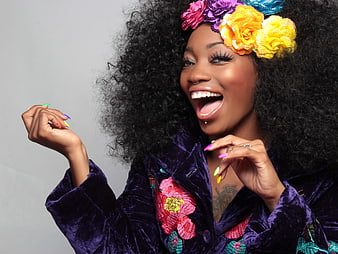 Joyful Woman with Afro Hair and Colorful Flower Headband