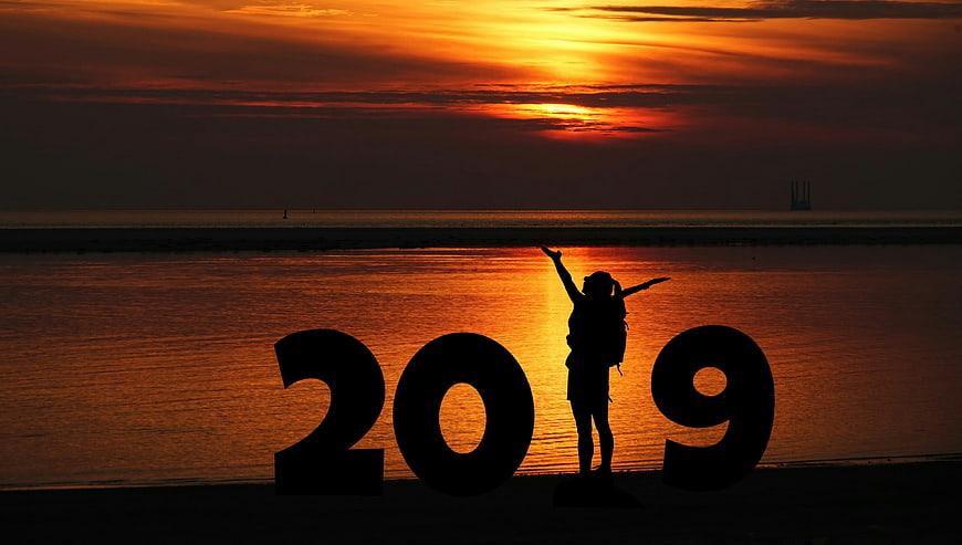 Silhouette of woman with 2019 cutout at sunset