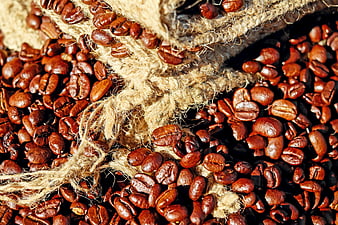 Close-up of roasted coffee beans spilling from a burlap sack