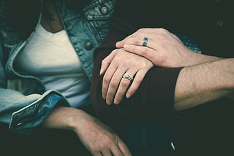 Close-up of couple holding hands with wedding rings