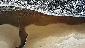 Aerial View of Ocean Waves Meeting Sandy Beach Shore