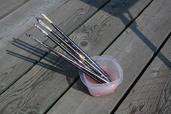 Paintbrushes soaking in water on wooden deck